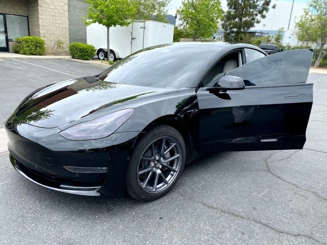 Black sports car with newly tinted windows parked in commercial lot