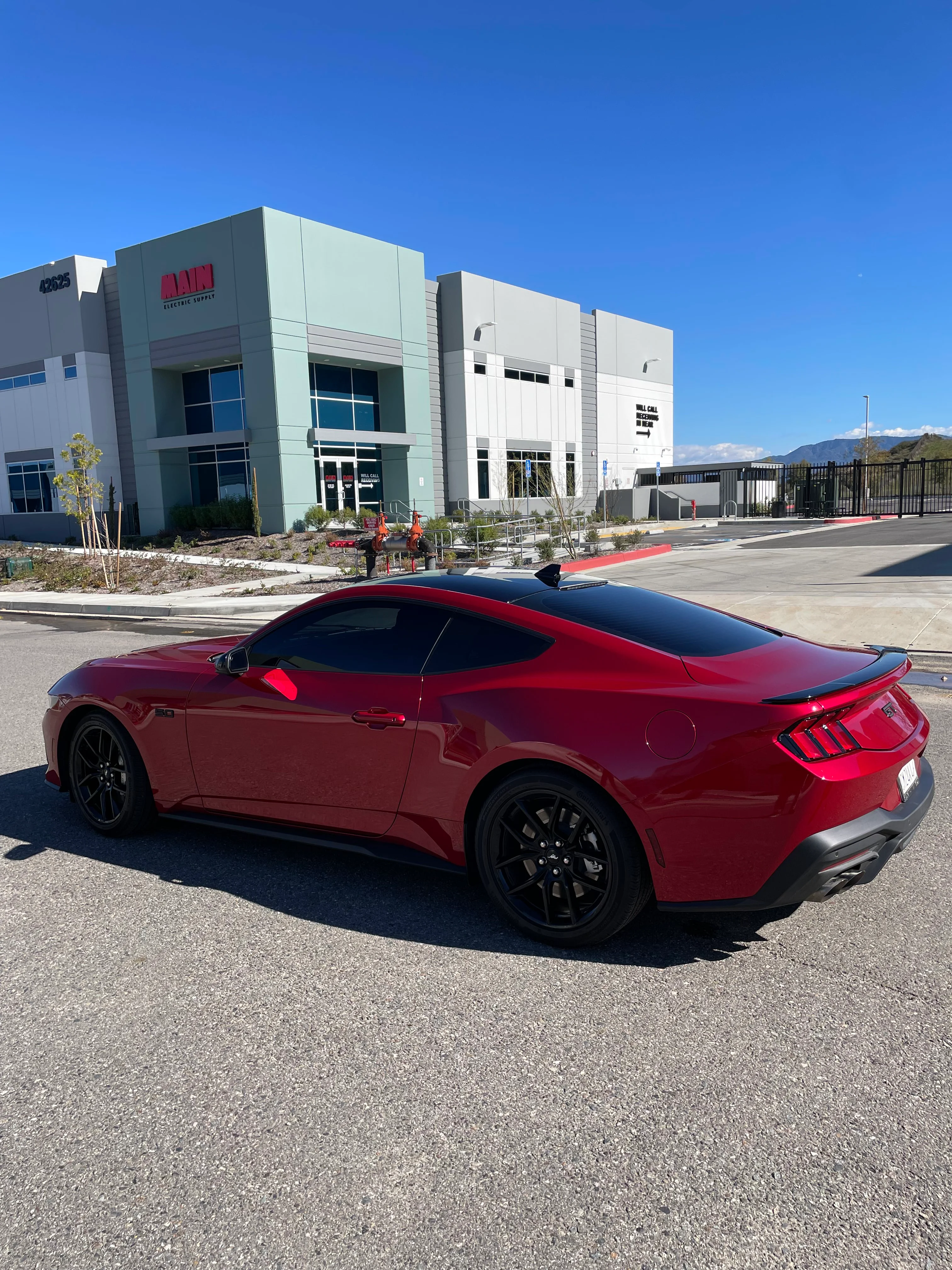 Red Mustang with professional window tint installed at Dead Eye Tint facility
