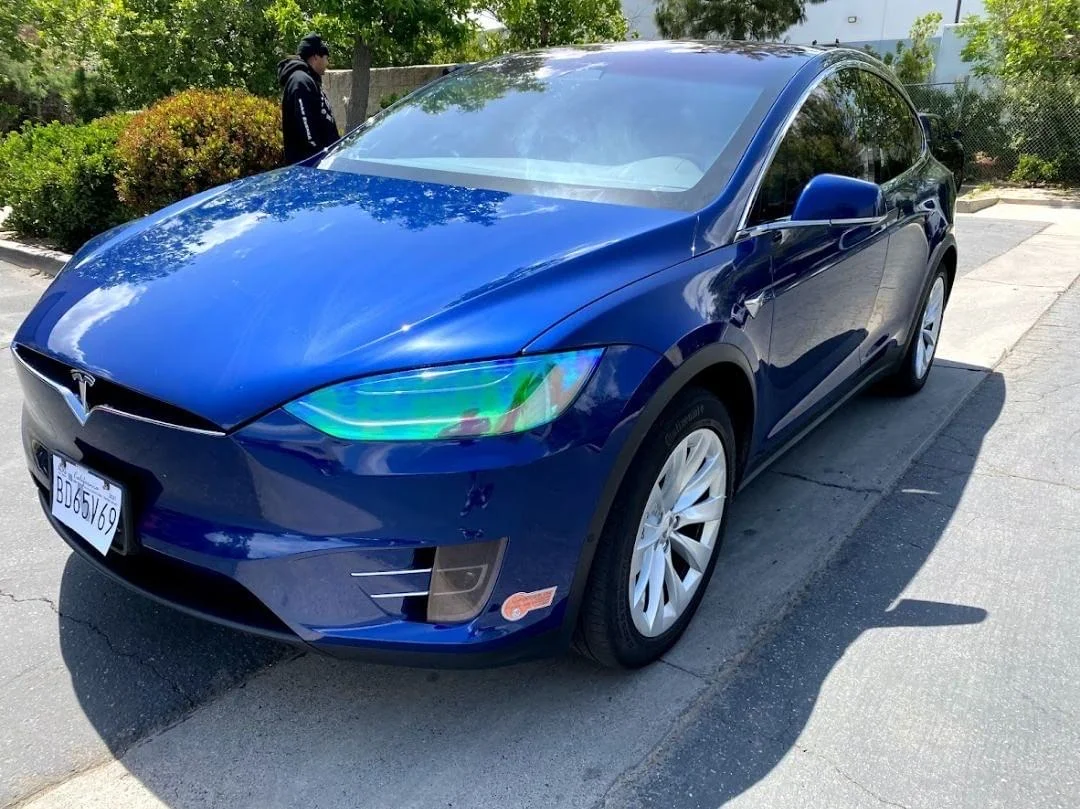 Blue Tesla Model X with freshly applied window tint on all windows, parked in driveway