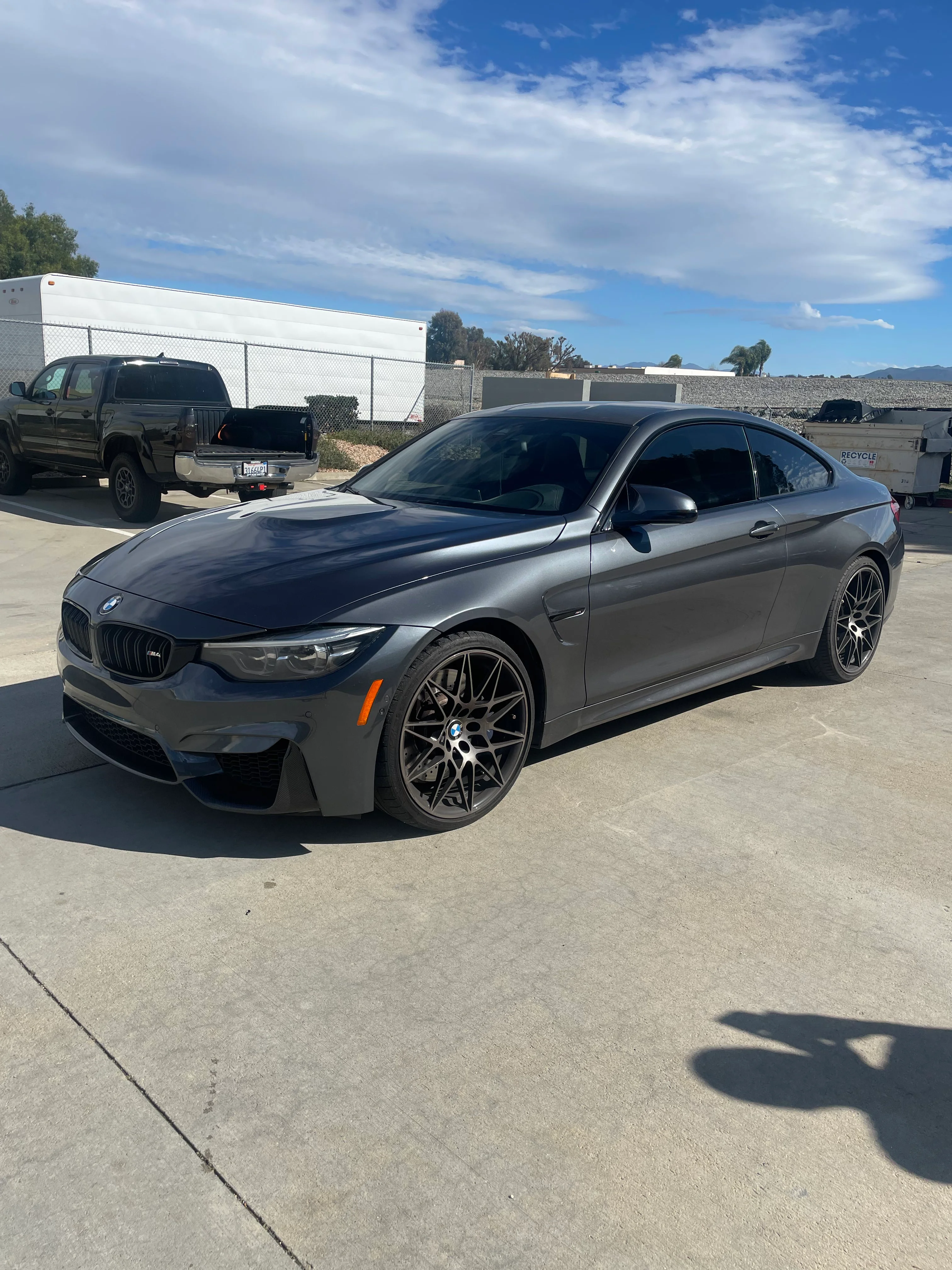 Gray BMW M440i with dark window tint applied, parked in commercial lot