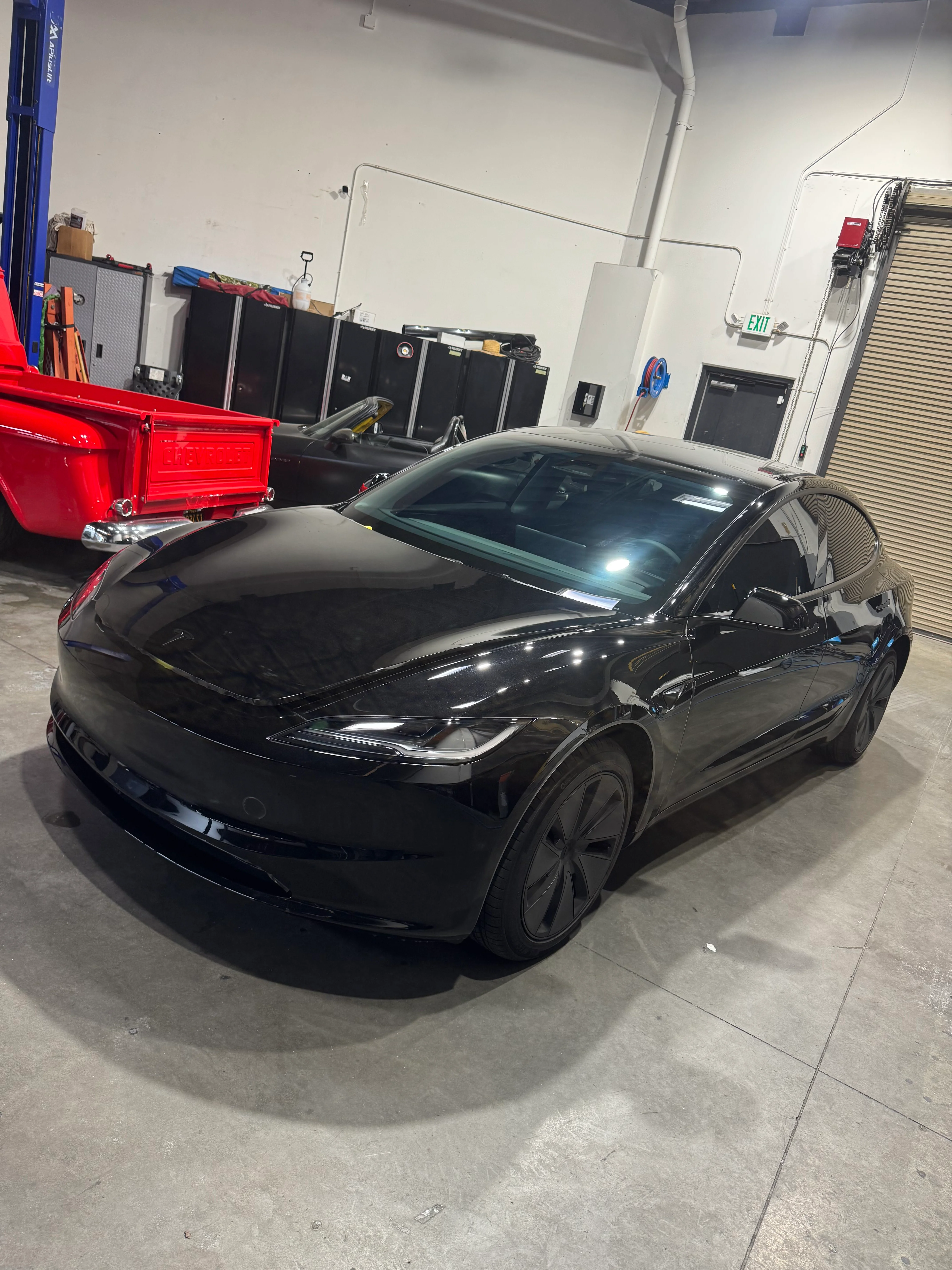 Black sedan with professionally installed window tint in service bay
