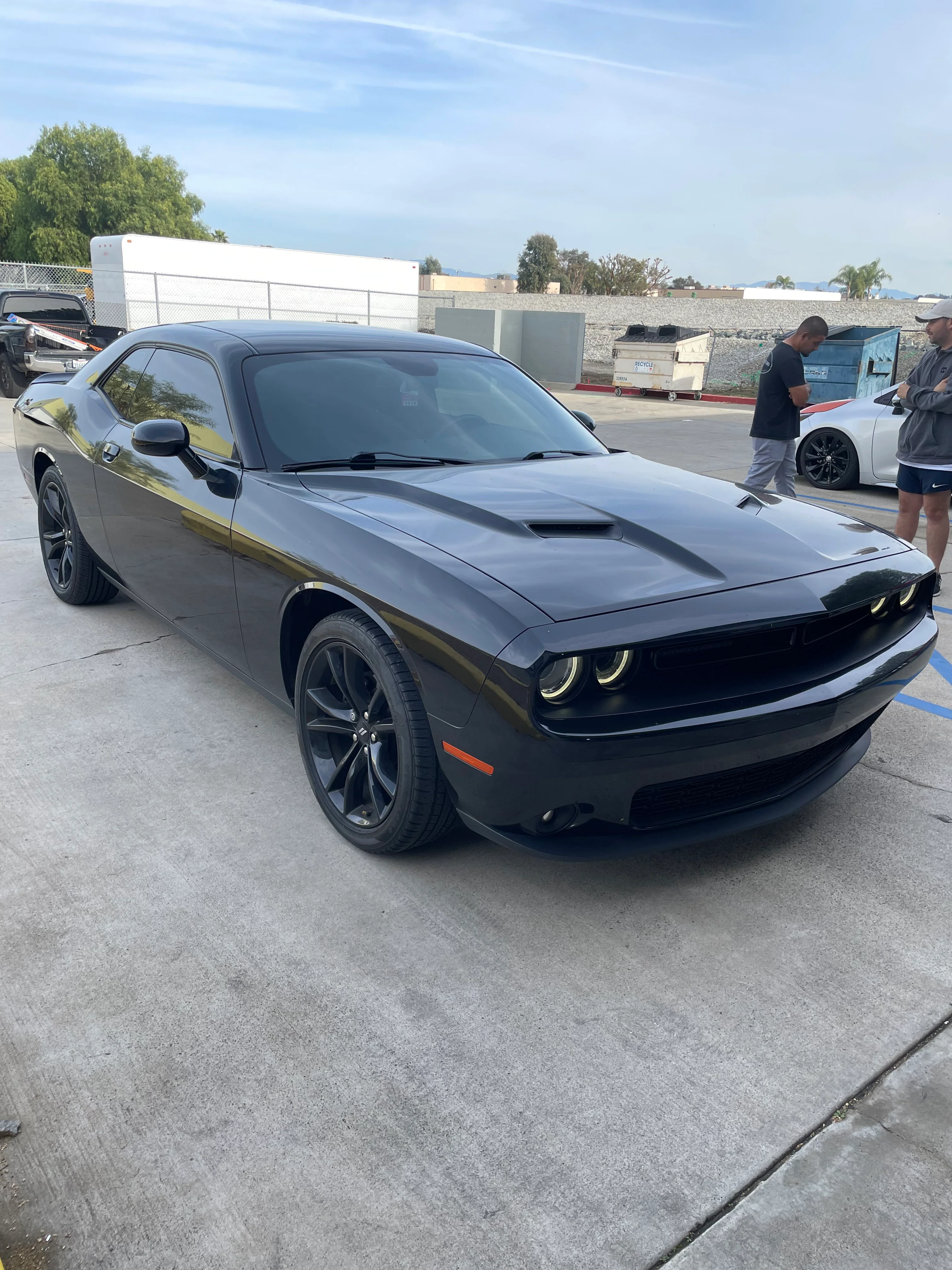 Black Dodge Challenger with professional window tint installed in service bay