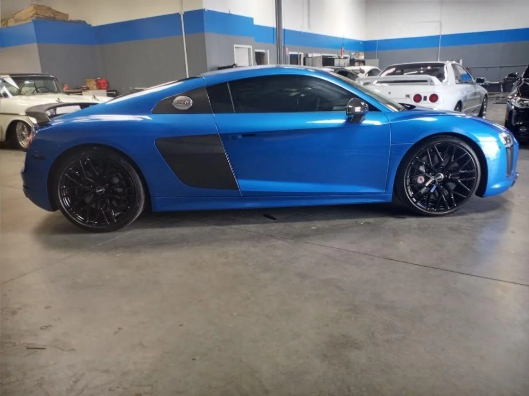 Blue Audi R8 with dark window tint in professional garage facility