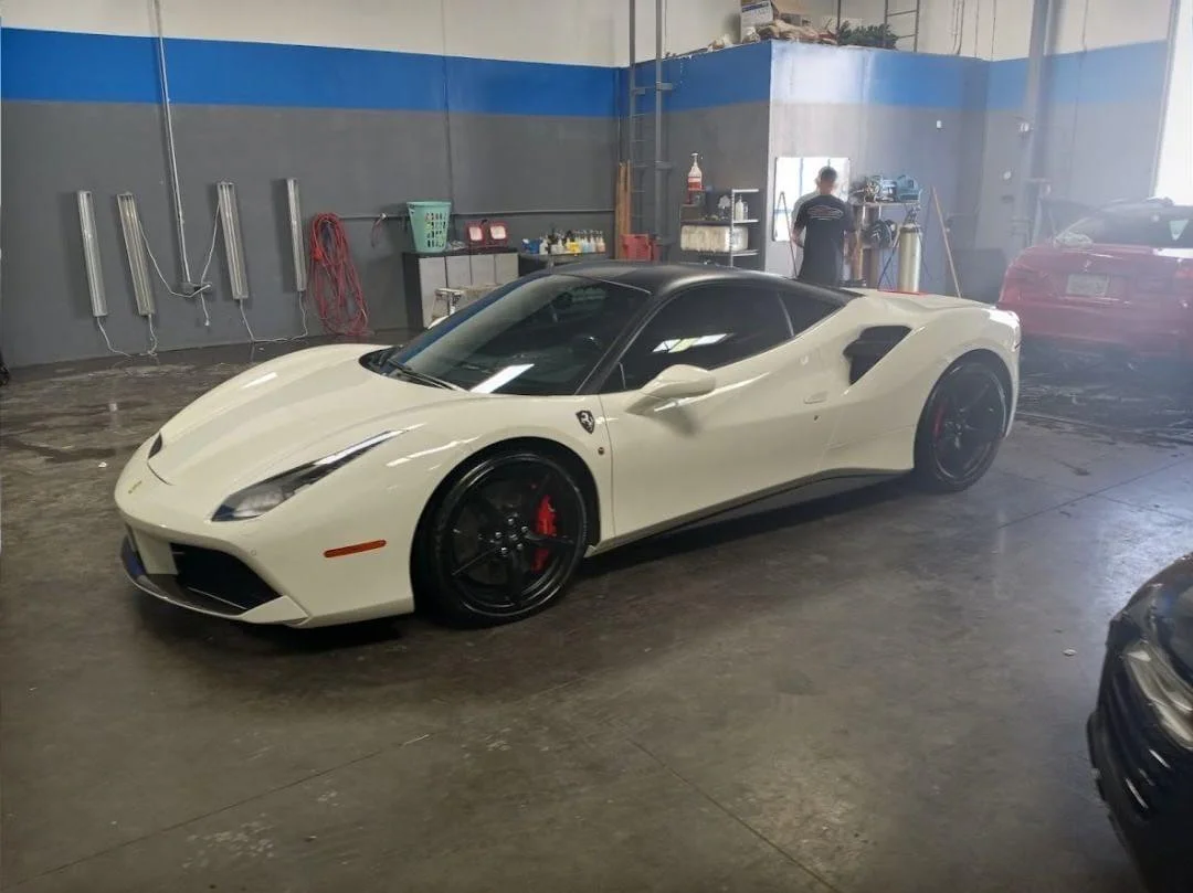 White luxury sports car with dark window tint in professional garage bay