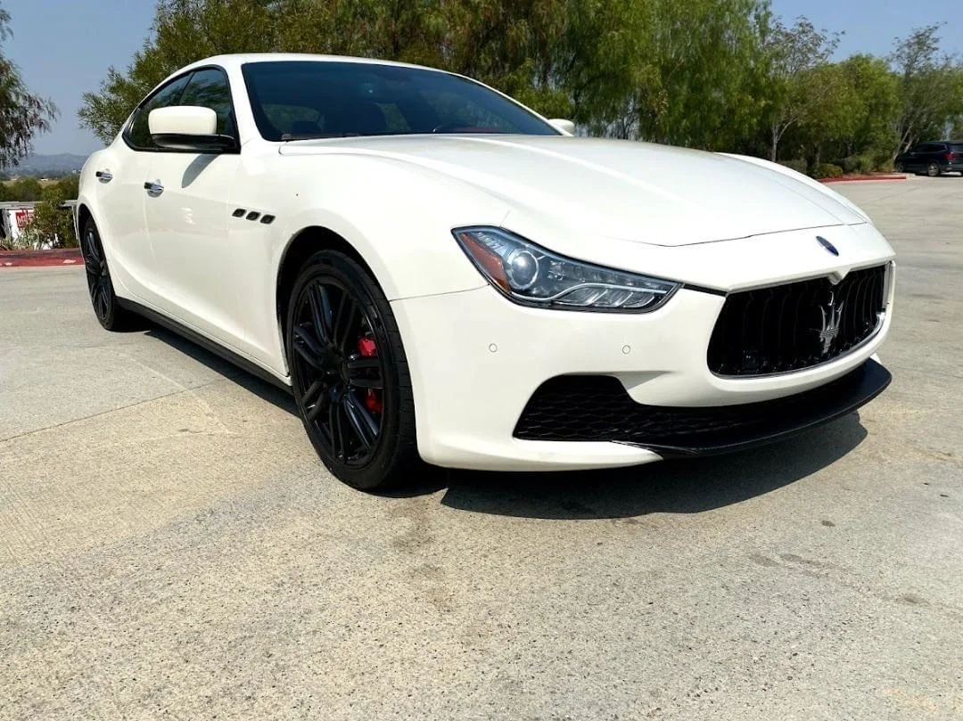 White Maserati sedan with dark window tint installed on all windows in parking lot