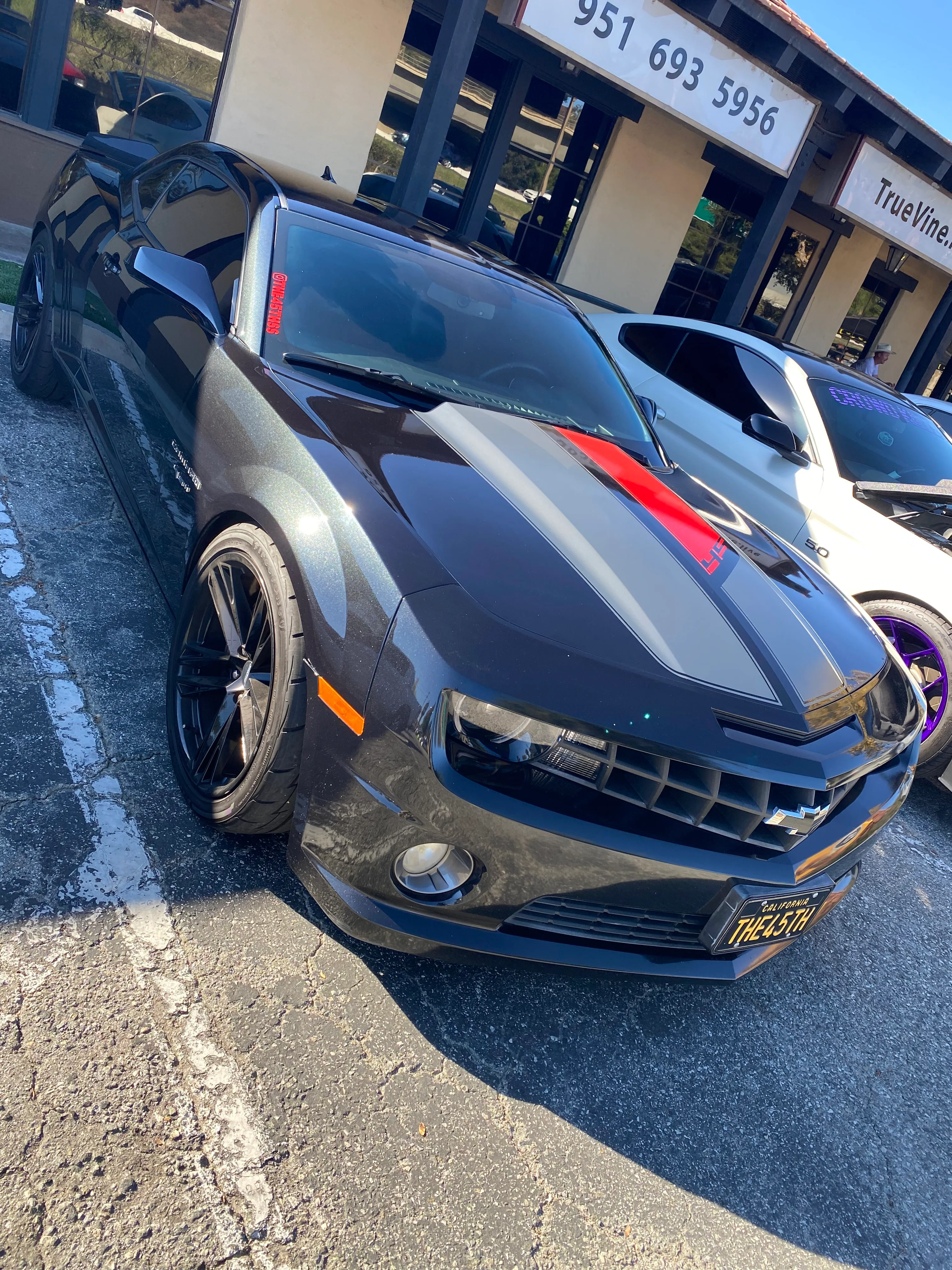 Black Chevrolet Camaro with dark window tint and custom amber accent lighting